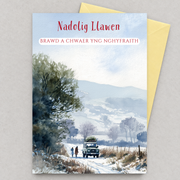 Cerdyn Nadolig ar gyfer Brawd a Chwaer yng Nghyfraith gyda tirwedd gaeafol, cerddwyr a cherbyd ar lôn eira, yn gorwedd yn fflat gydag amlen felen / Welsh Christmas card for a brother and sister-in-law, lying flat with an envelope