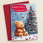 Cerdyn Nadolig Gwraig Arbennig – Calonnau / Welsh Christmas card with a teddy and a Christmas tree with red hearts, lying flat beside a deep red envelope.
