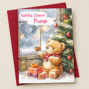Cerdyn Nadolig Mamgu – Tedi a Choeden / Welsh Christmas card with a teddy beside a Christmas tree, lying flat beside a deep red envelope.